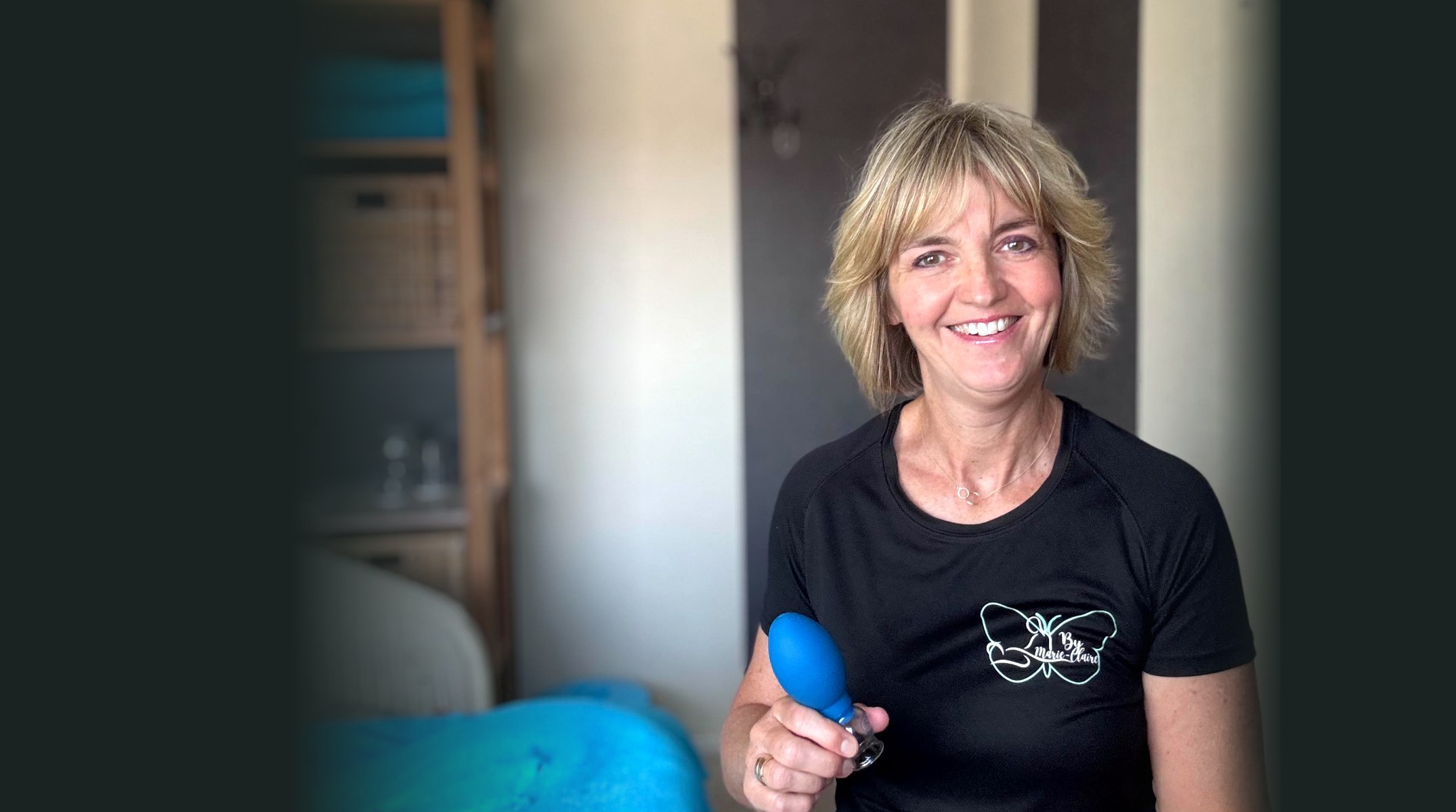 Marie-Claire in haar behandelruimte met een blauwe cup in haar hand